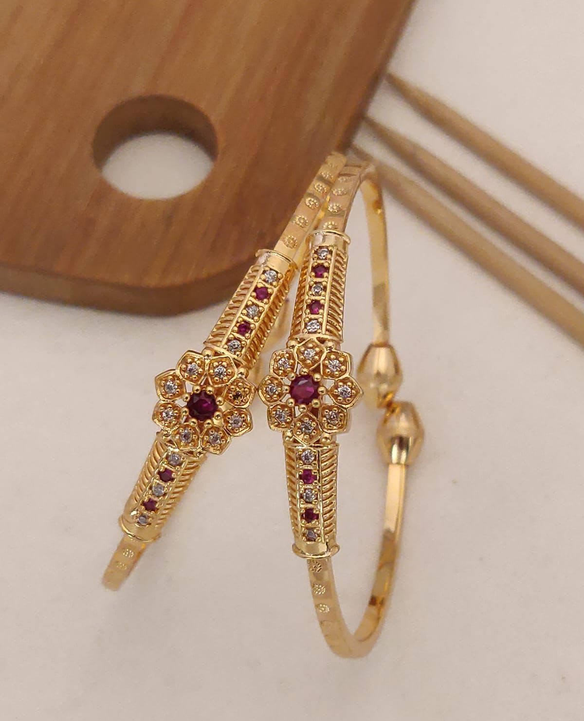 Delicate And Elegant Gold Bangles With A Floral Design And Sparkling White Stones, Perfect For Any Special Occasion.