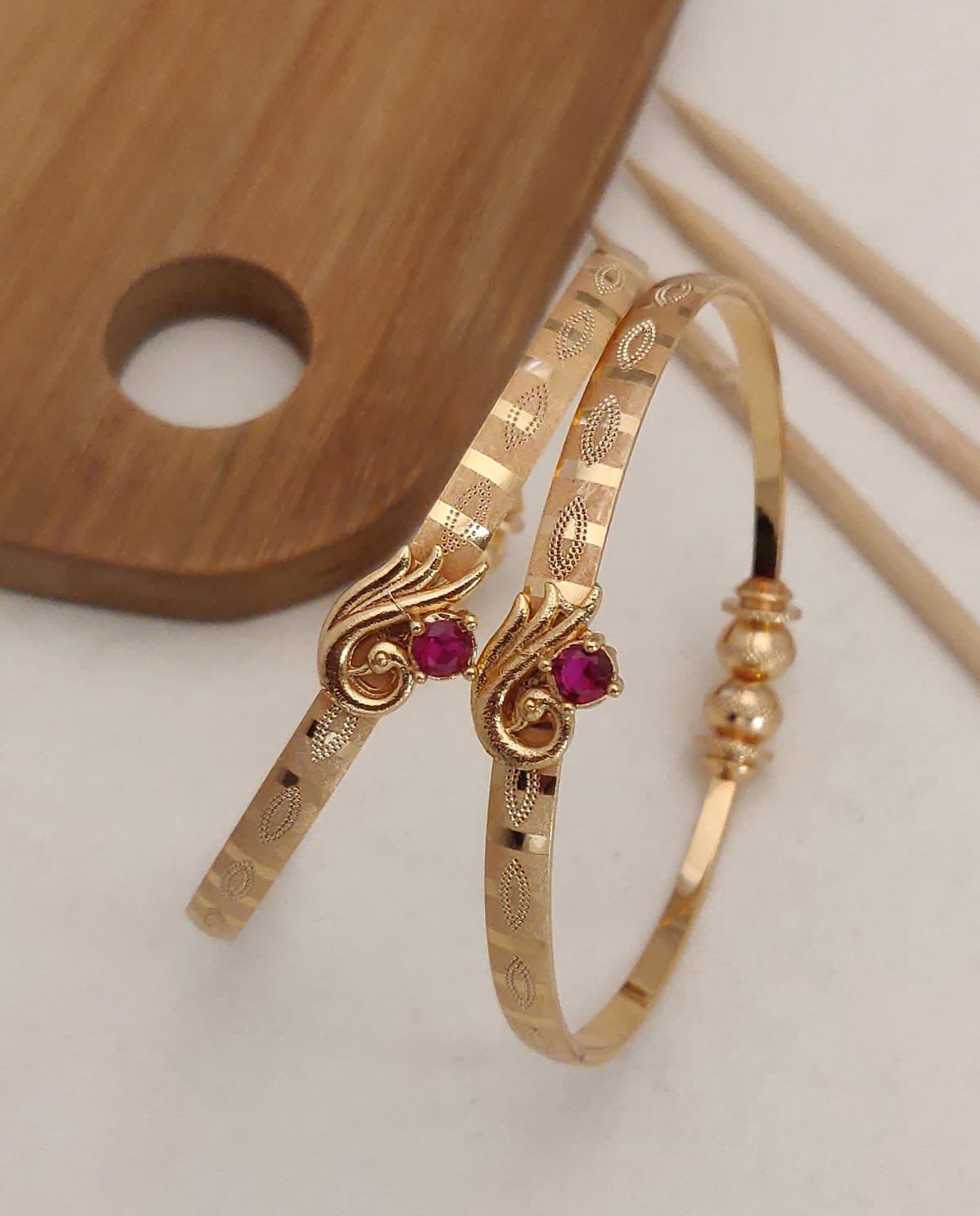 Delicate and elegant gold bangles with a touch of pink